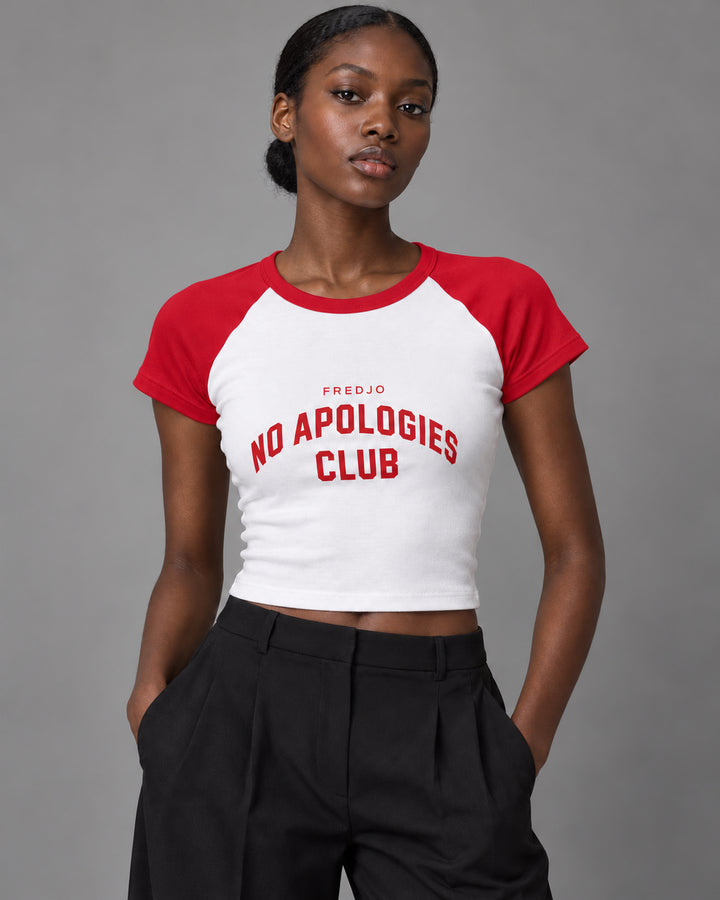 No Apologies Club baby tee in white and red, worn by a woman